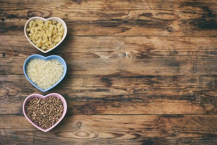 Assorted grains and pasta ingredients arranged on a wooden table