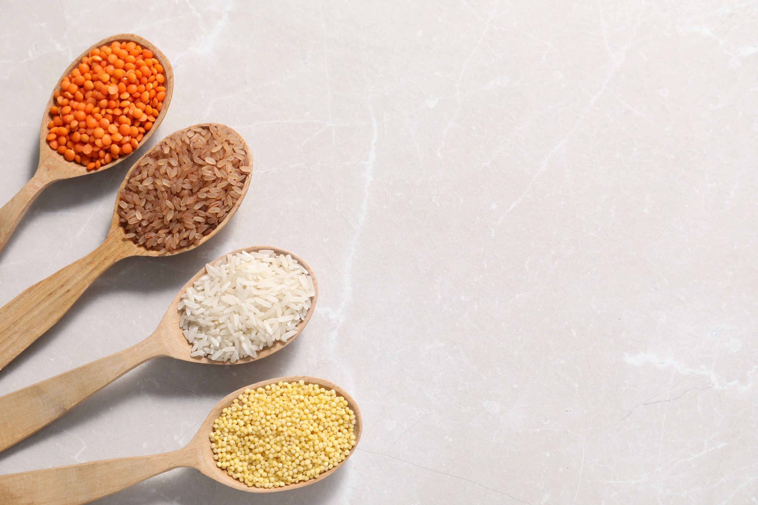 Wooden spoons with legumes and cereals flat lay