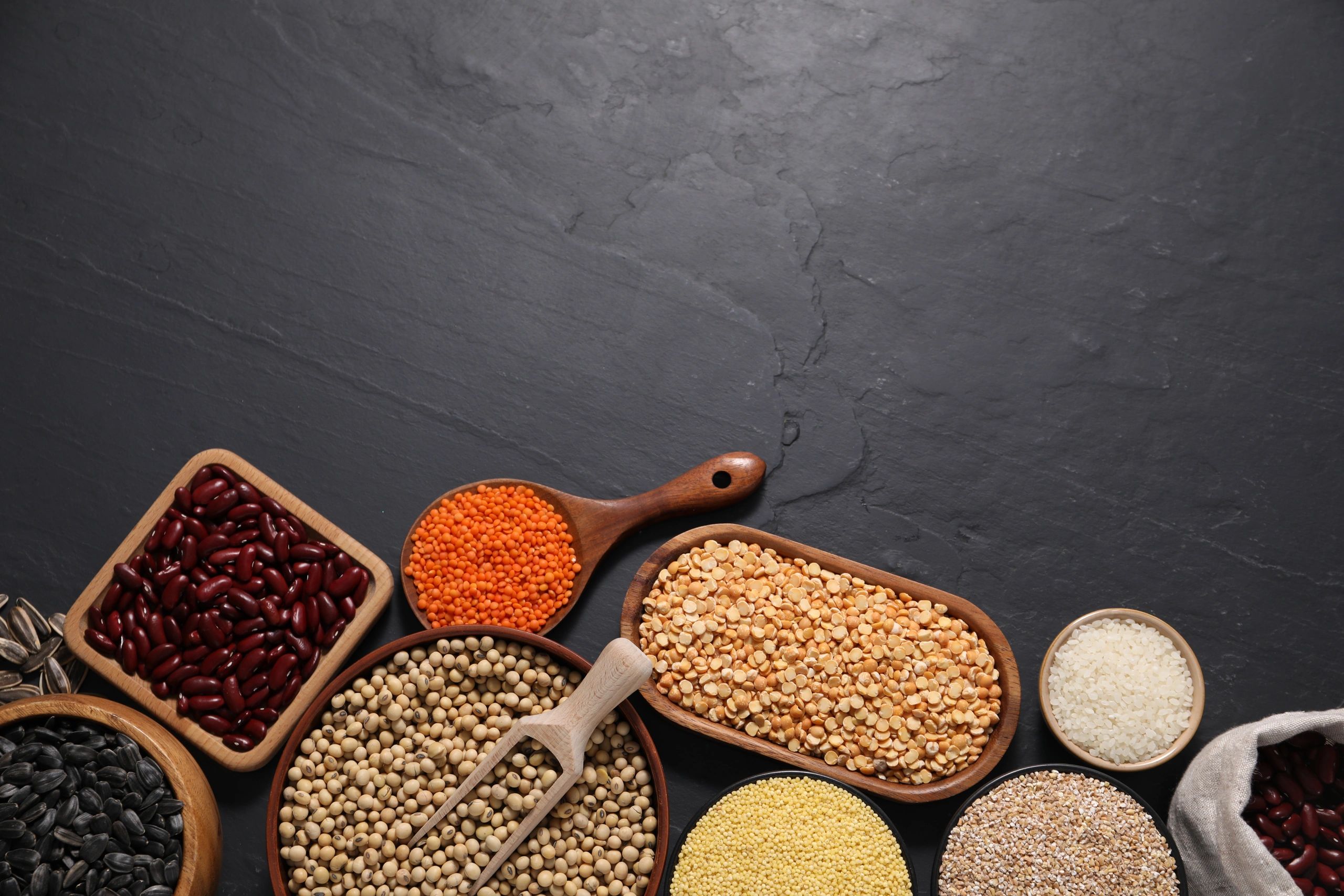 Cereals, seeds and legumes on grey table flat lay