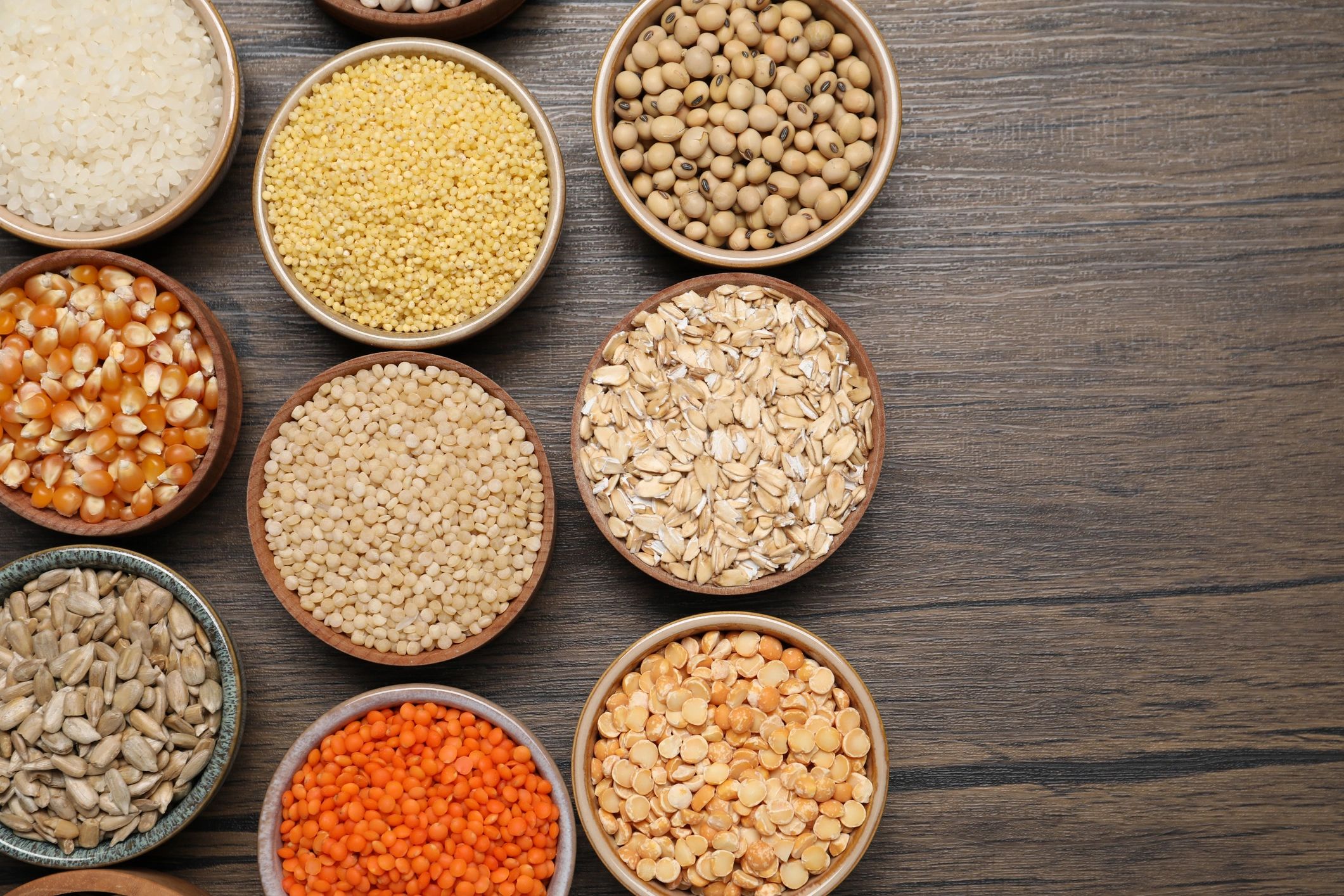 Bowls of cereals, seeds and legumes flat lay